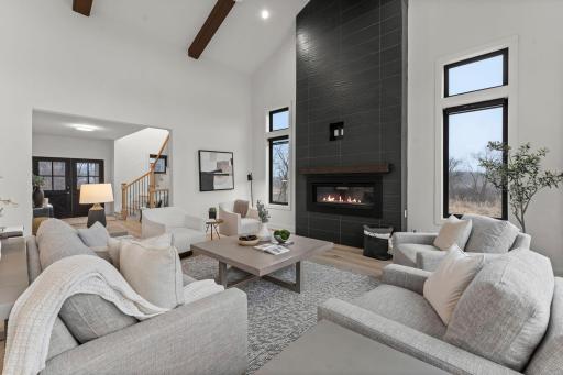 A striking floor-to-ceiling tiled gas fireplace serves as the stunning centerpiece of the great room, adding warmth and modern elegance to the space.
