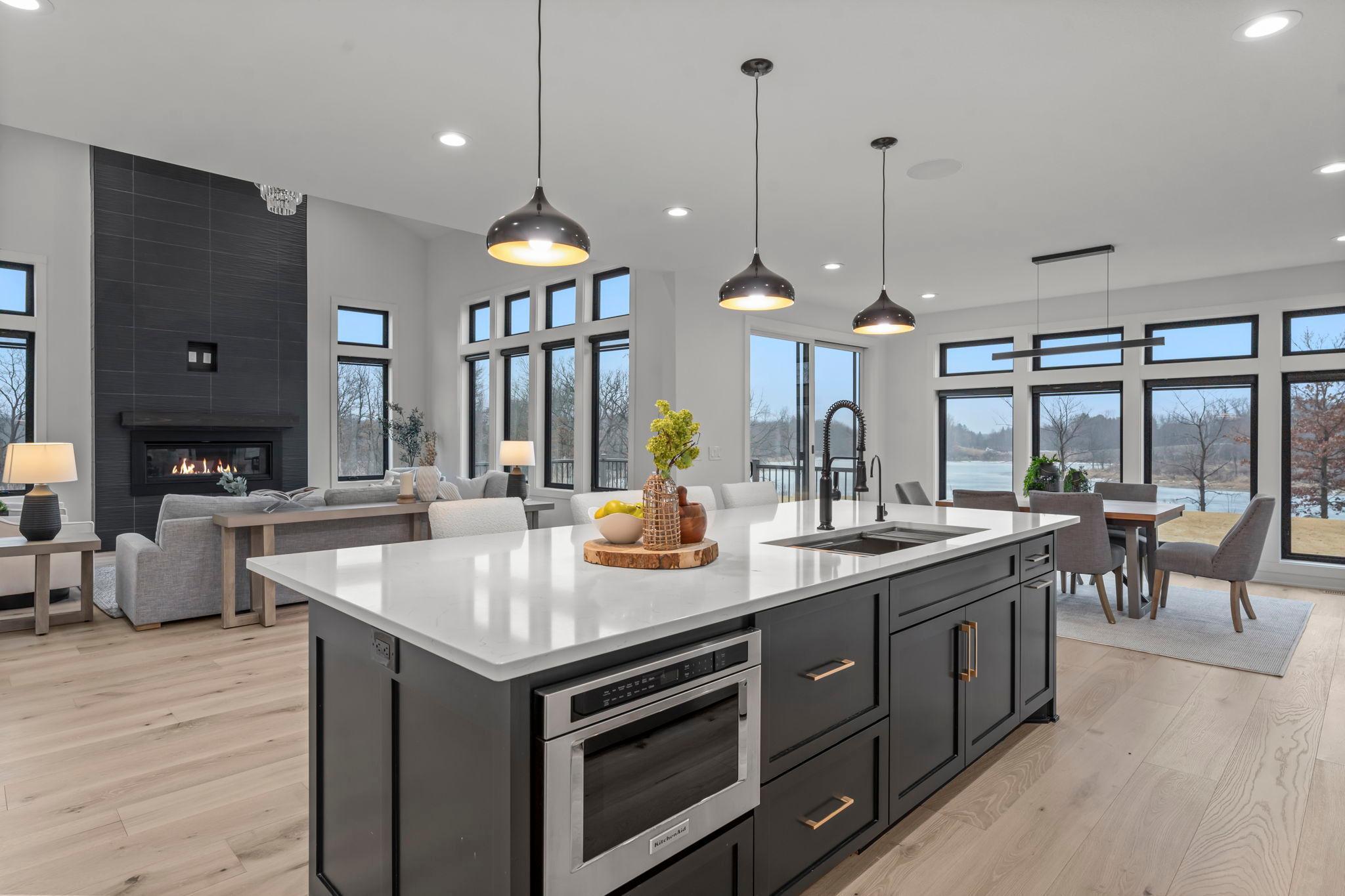 A quartz island countertop is the kitchen’s centerpiece, offering durability, sophistication, ample workspace, storage, and casual dining. The dishwasher is concealed behind custom cabinet panels to maintain a clean design.