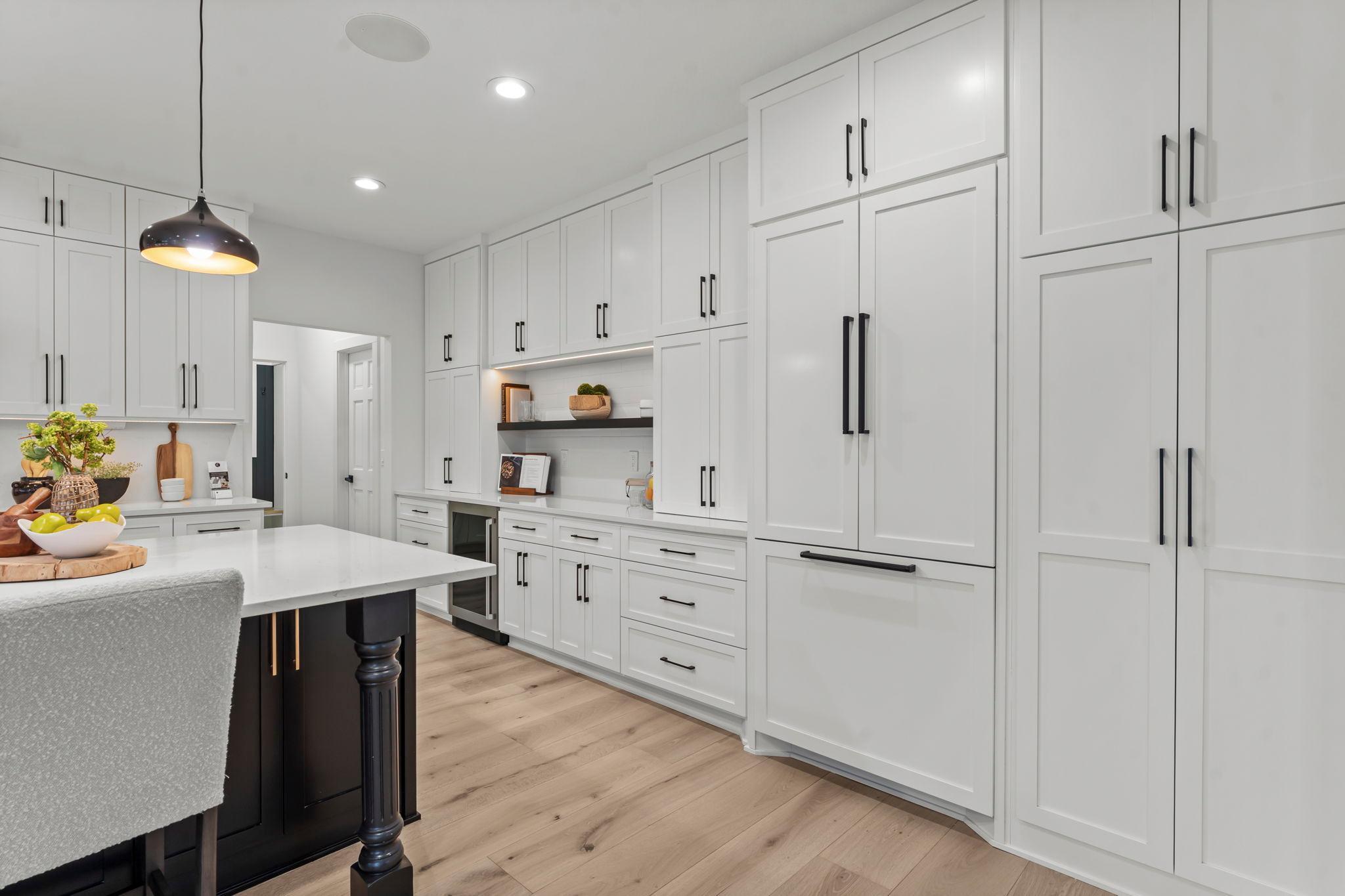 The kitchen features a built-in refrigerator seamlessly integrated with custom cabinetry for a sleek, cohesive look.