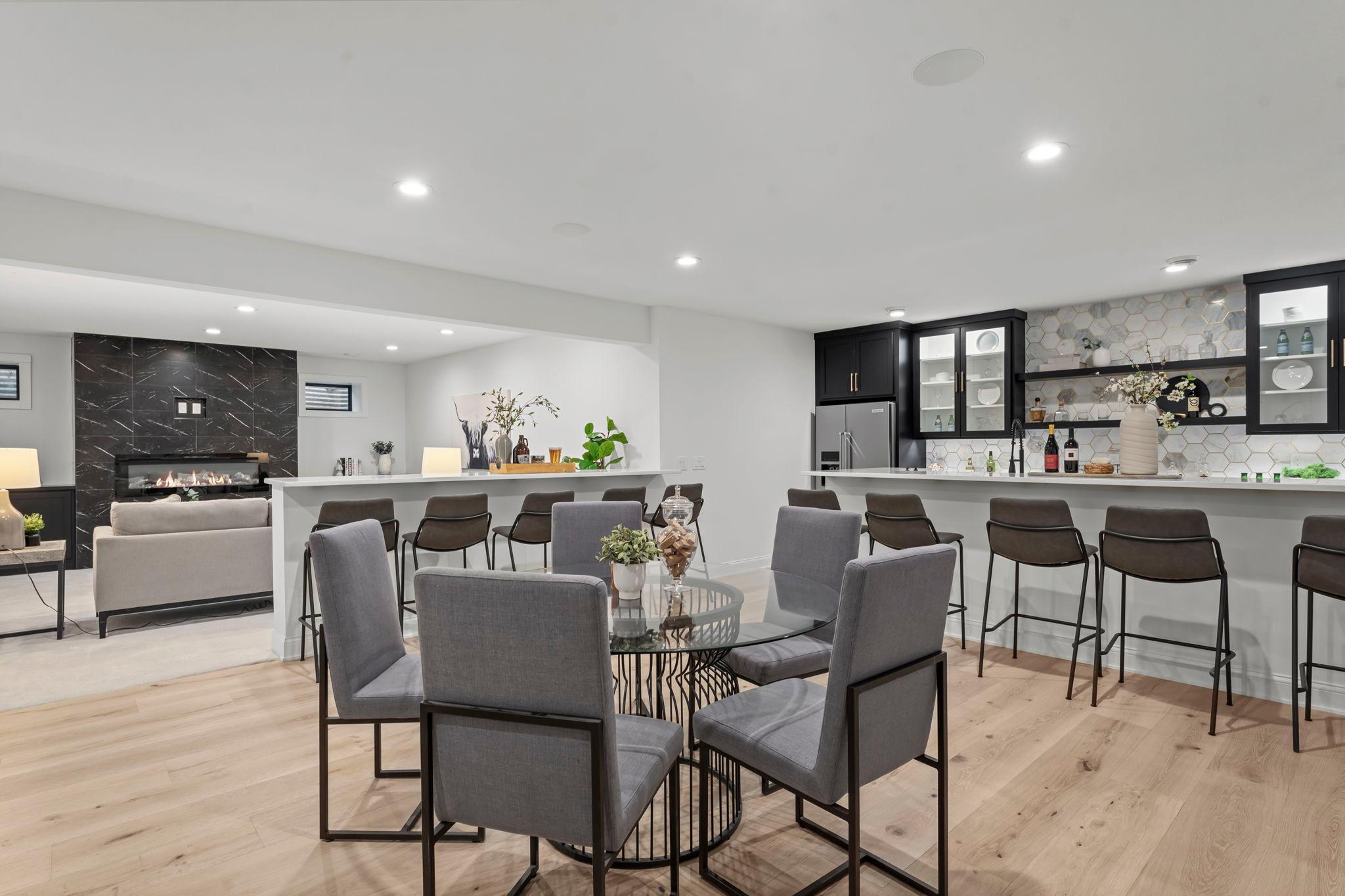 Recessed lighting and built-in speakers throughout the space ensure an inviting atmosphere. This lower level seamlessly provides a versatile and luxurious living area.