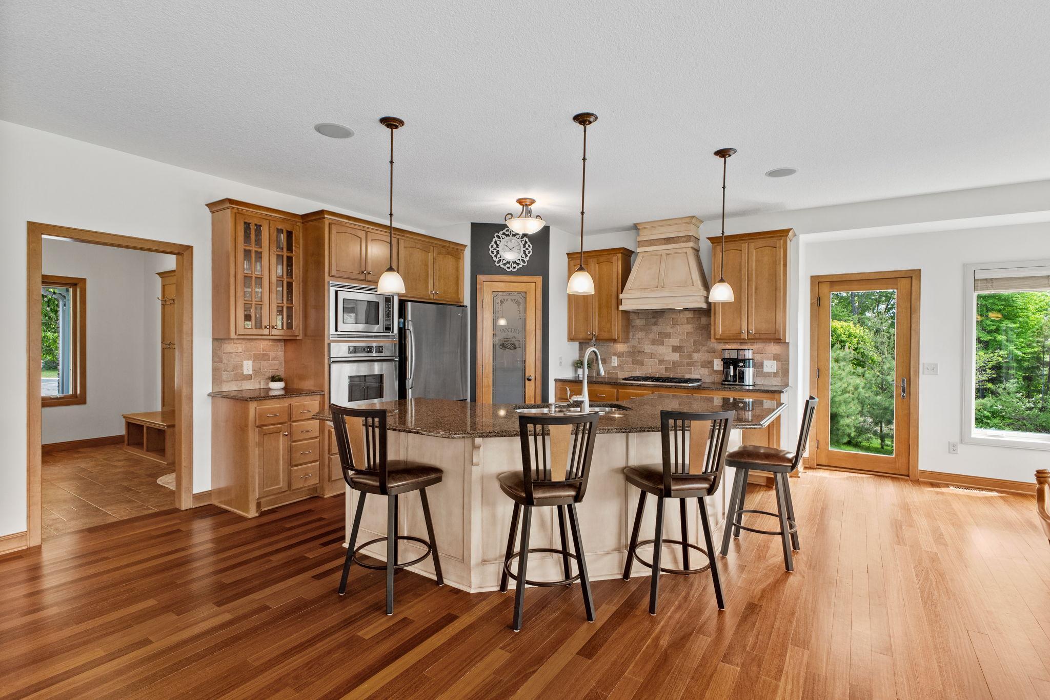 The heart of the home is a designer blend of finishes, warm natural wood floors, custom cabinetry, a spacious center island and space for the entire family to gather. 9' ceilings on the main level add to the open & airy feel of this home.
