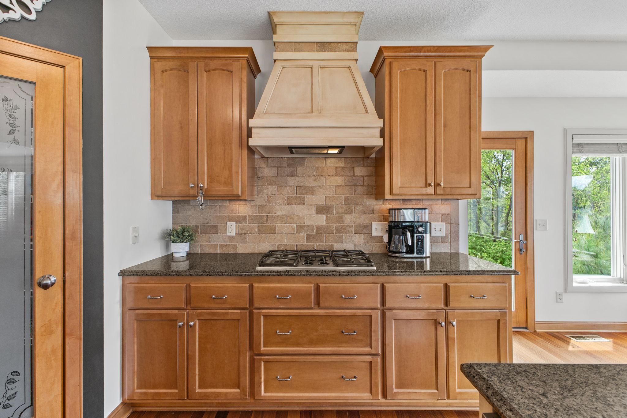 The gourmet chef in the family will feel like a professional with the cooktop, custom vented hood, custom tiled backsplash and spacious pantry.