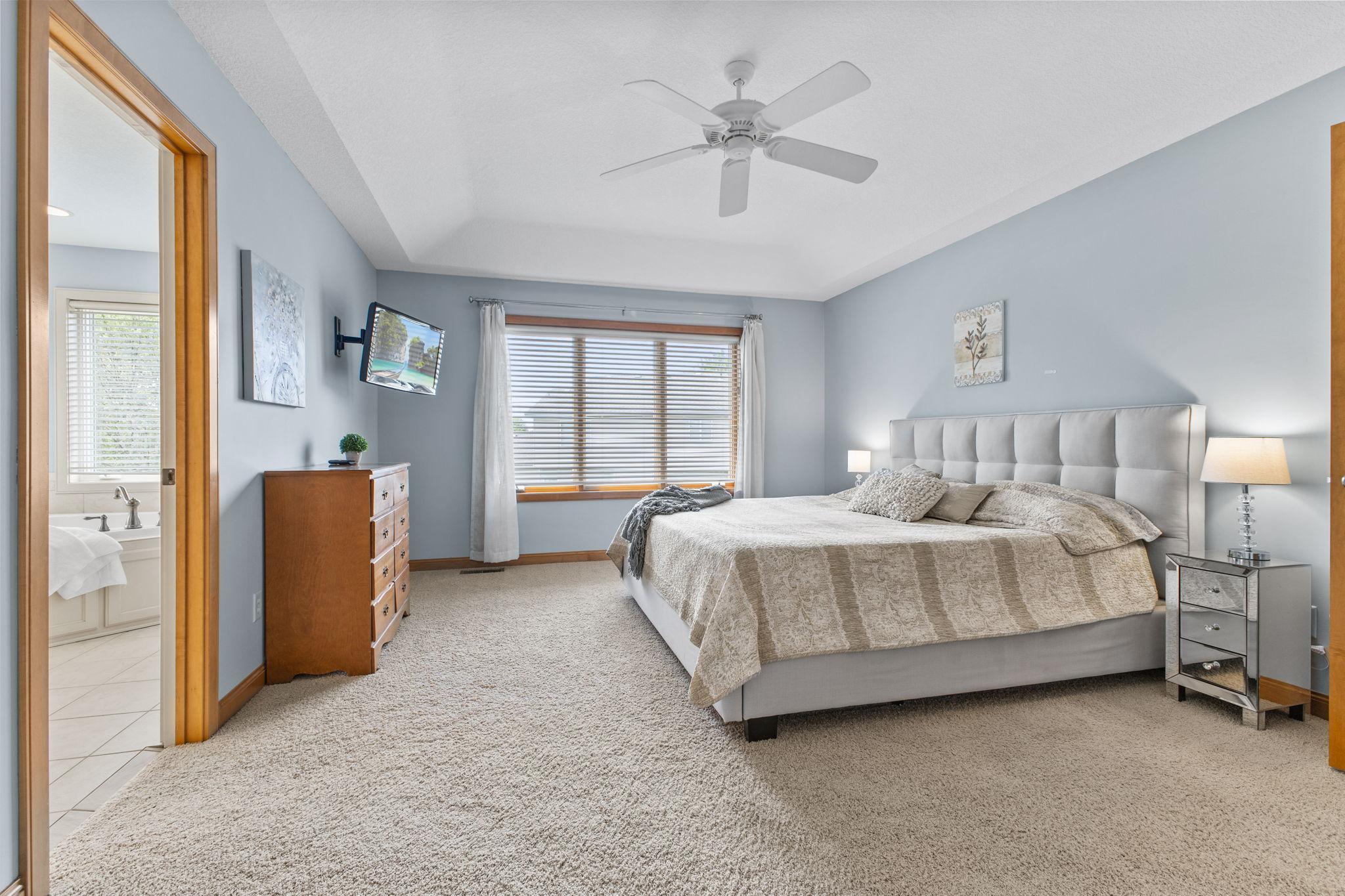 Primary ensuite! Custom window treatments, ceiling fan & neutral carpeting.