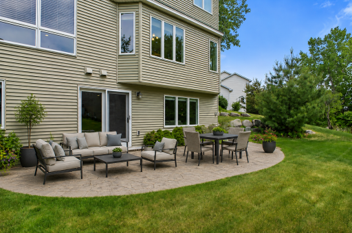 The custom back patio offers ample space to relax and catch beautiful sunsets with serene wetlands framing your yard. This virtually staged patio showcases how spacious it is.