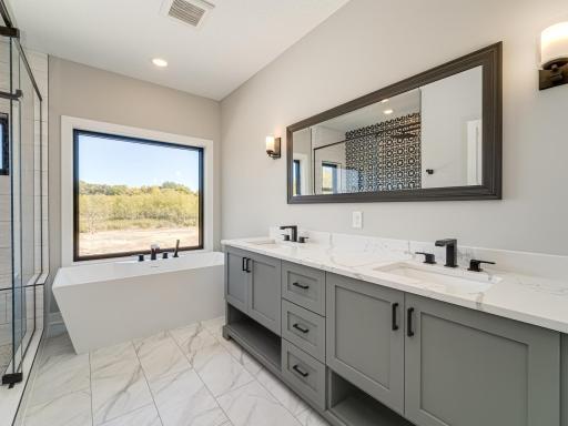 Primary Owner's Suite private bathroom comes complete with tile floors, dual vanity sinks, huge tub and separate oversized walk-in shower.