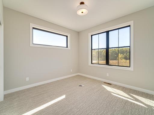 This is the 3rd bedroom at the corner of the home boasting tons of natural light with both oversized windows AND an upper transom window for above the bed frame/setup.