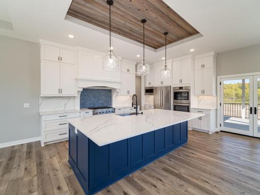 The main level features primarily 9ft high flat ceiling with decorative insets that jump to 10ft high like here where the wood paneling accents are atop the large center island. Floor to ceiling kitchen cabinets = tons of storage space for all needs.