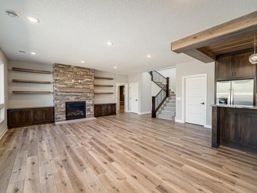 Enjoy 9ft tall ceilings throughout the entire lower level. The enormous family room comes with another stone gas-burning fireplace, lower cabinets, floating shelves and a full wet-bar too!!