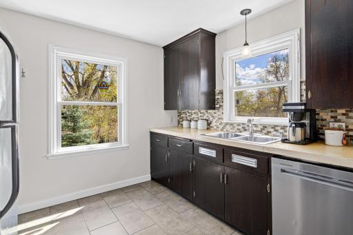 The bright kitchen features concrete counters and tile floors