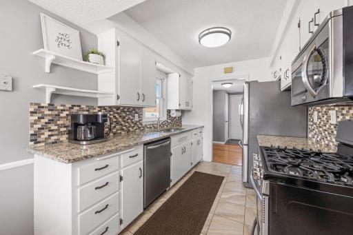 Thoughtful updates throughout the home including granite countertops, tile backsplash and stainless steel appliances int he kithen.