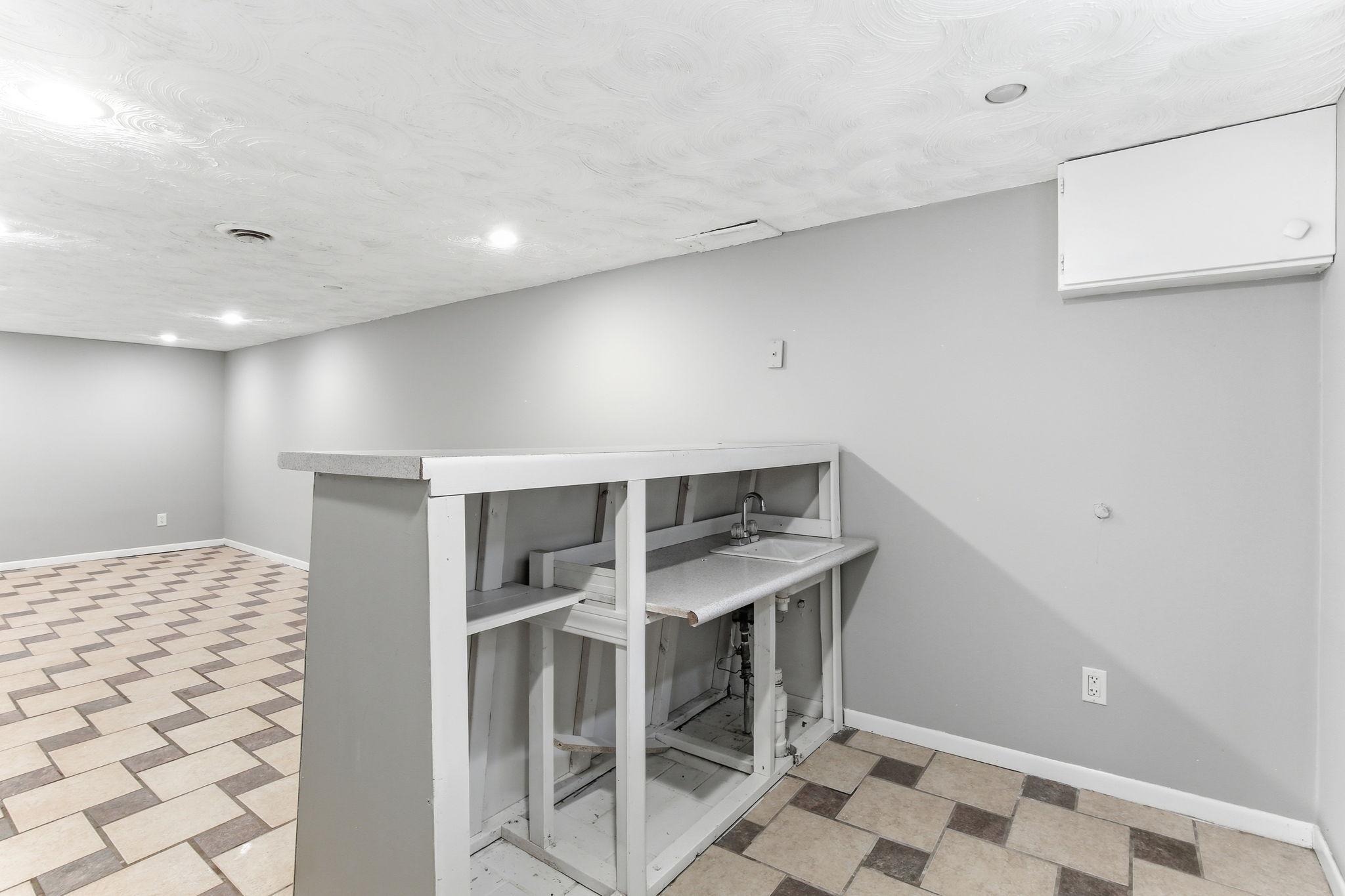 Lower-Level Bar Setup with Plumbing—Perfect Opportunity to Finish & Add Value