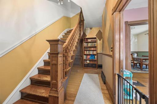 Stairway upstairs with victorian styled wood trim and walls