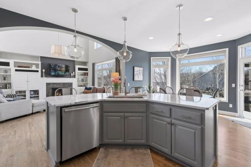 Designed for gathering, the spacious kitchen features a large quartz island with kitchen sink and plenty of sunlight.