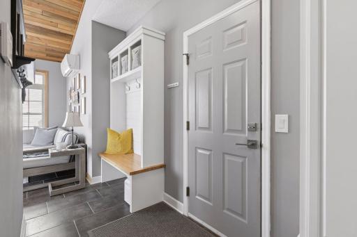 The mudroom features built-in lockers and cabinets just off the garage entry for easy organization. The large three -car garage has a Tesla Supercharger installed.