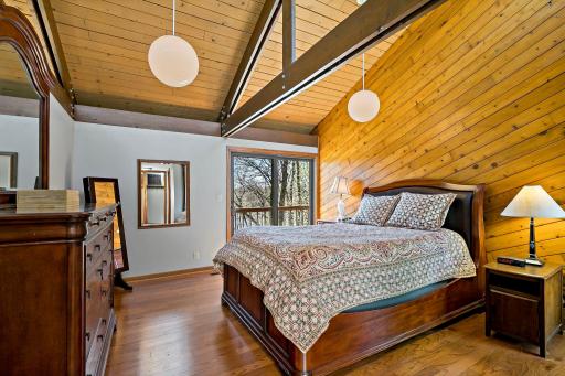Owner's suite is spacious with hardwood floors, beamed vaulted ceilings and patio doors that go to the deck!