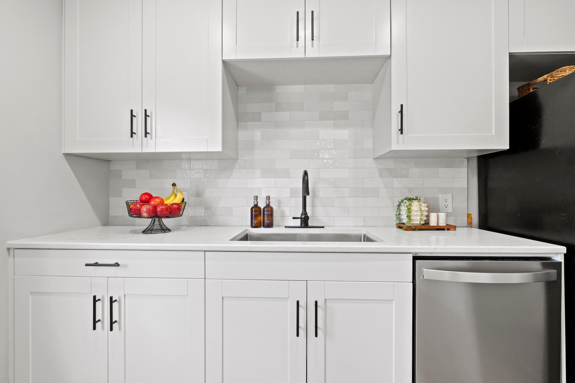 Kitchen full of updates - all new cupboards, new quartz countertops and tile backsplash, updated appliances, removed wall for open layout, and new lighting