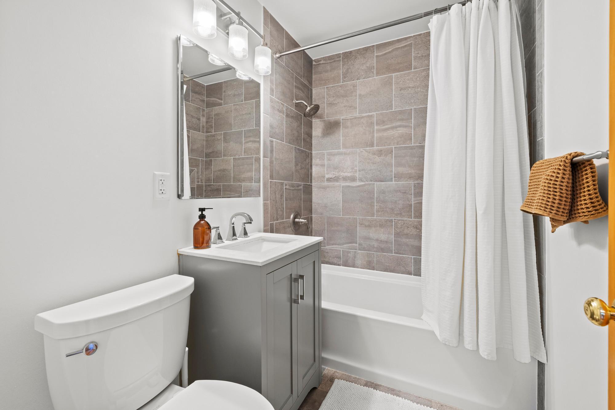 Updated main floor bathroom - all new tile tub surround and flooring, vanity, toilet, and tub