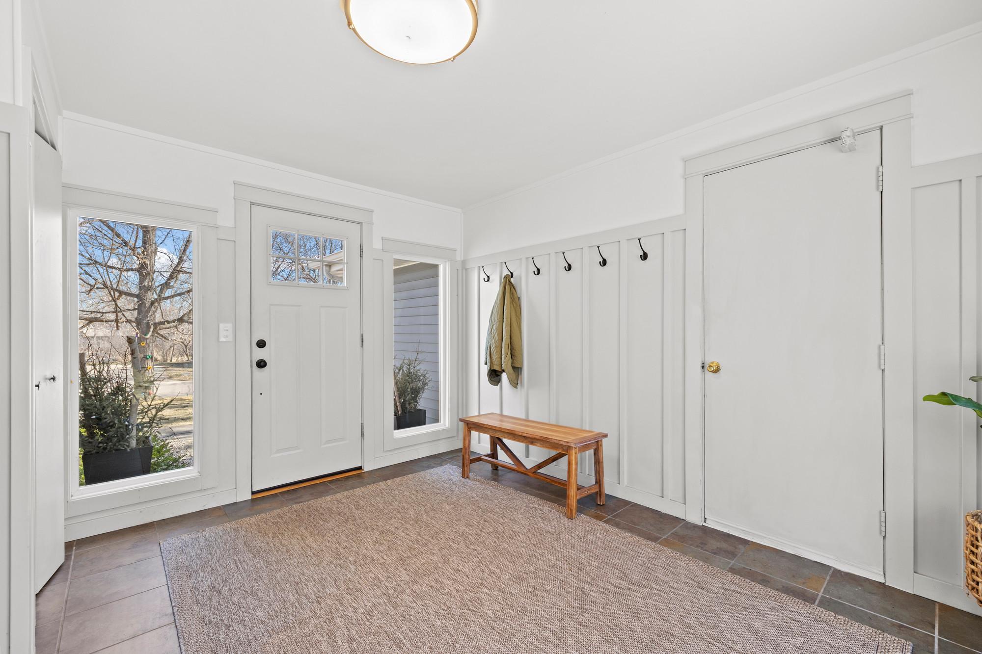 Updated breezeway with easy access to the garage, plenty of space to welcome guests, a closet to stow shoes and jackets, and a sliding glass door to the back patio