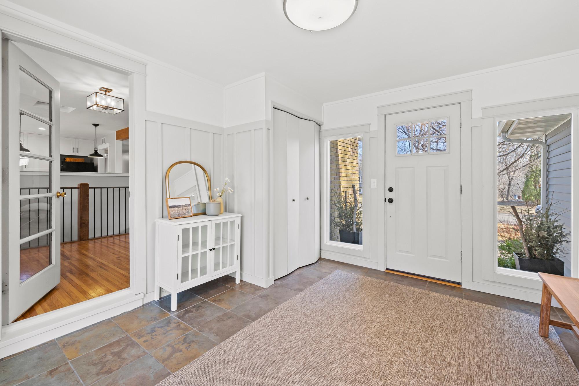 Updated breezeway with easy access to the garage, plenty of space to welcome guests, a closet to stow shoes and jackets, and a sliding glass door to the back patio