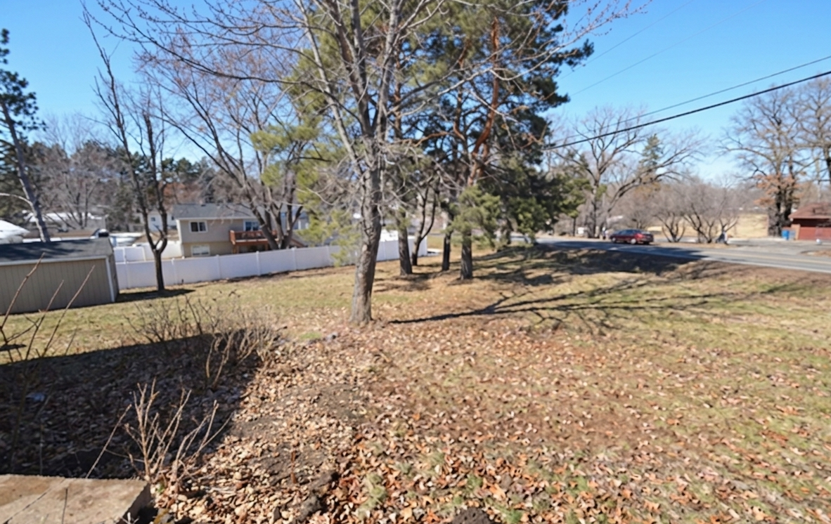 Spacious yard plus a firepit with concrete sitting area.