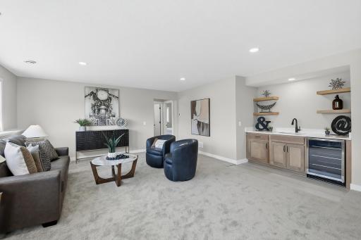 This lower level family room offers a wet bar and an abundance of sunlight.