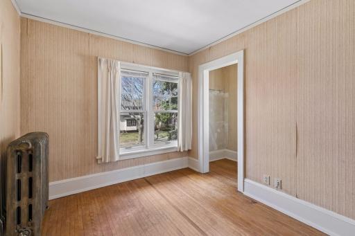 This first of three, bright upper level bedroom offers hardwood floors, a closet, overhead lights, and two windows.