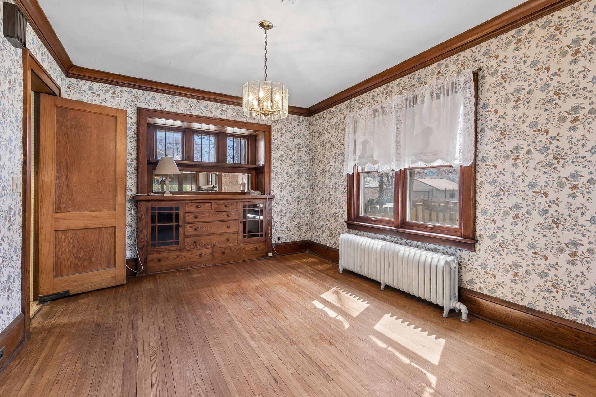 Dining space with built in buffet, crown molding, two windows, and chandelier; plenty of entertaining space and adjacent to the kitchen and living room!