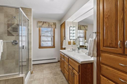 Main level bathroom with dual vanity and walk in shower and separate tub