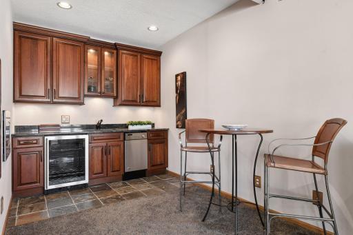 Lower level wet bar with beverage fridge, dishwasher and microwave makes this the perfect entertaining space