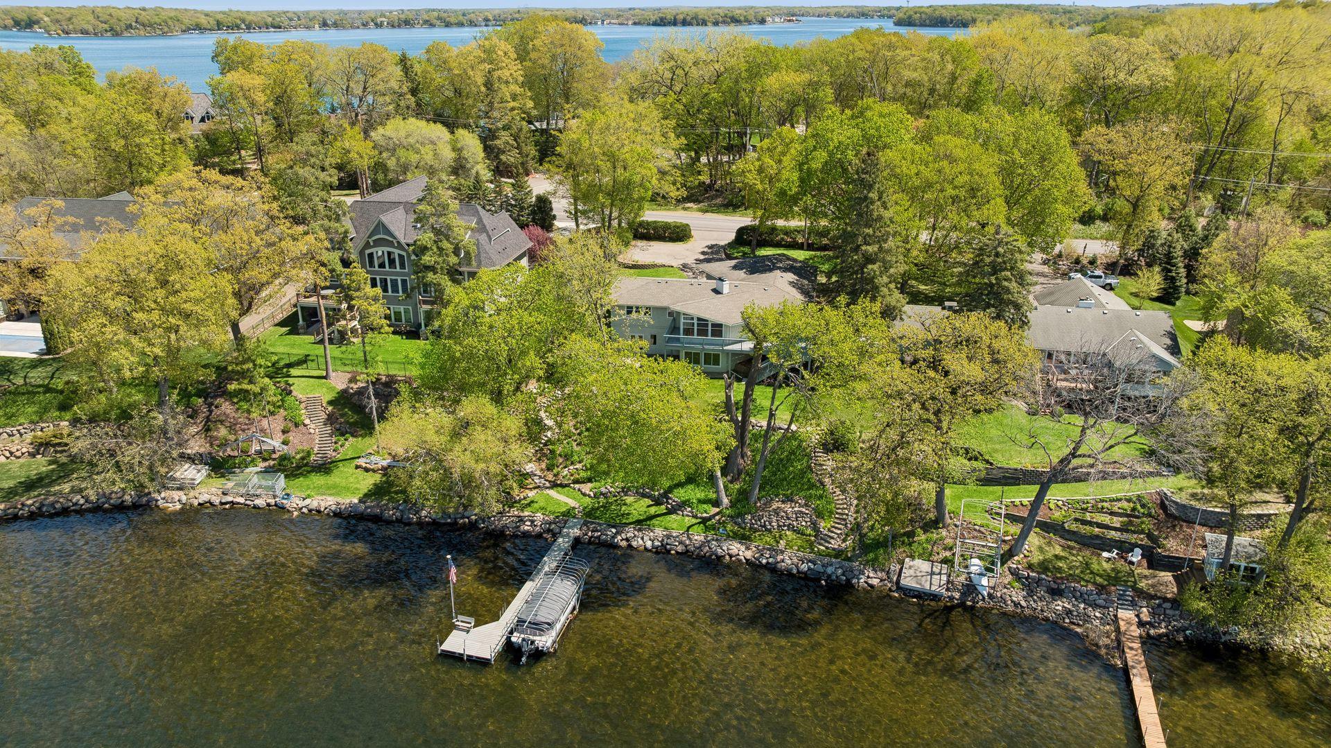 Welcome to this stunning 4 bed 4 bath rambler on over 100 ft of west facing lakeshore on Halstead Bay. Twilight view of the front exterior with spacious driveway and attached 3 car garage.