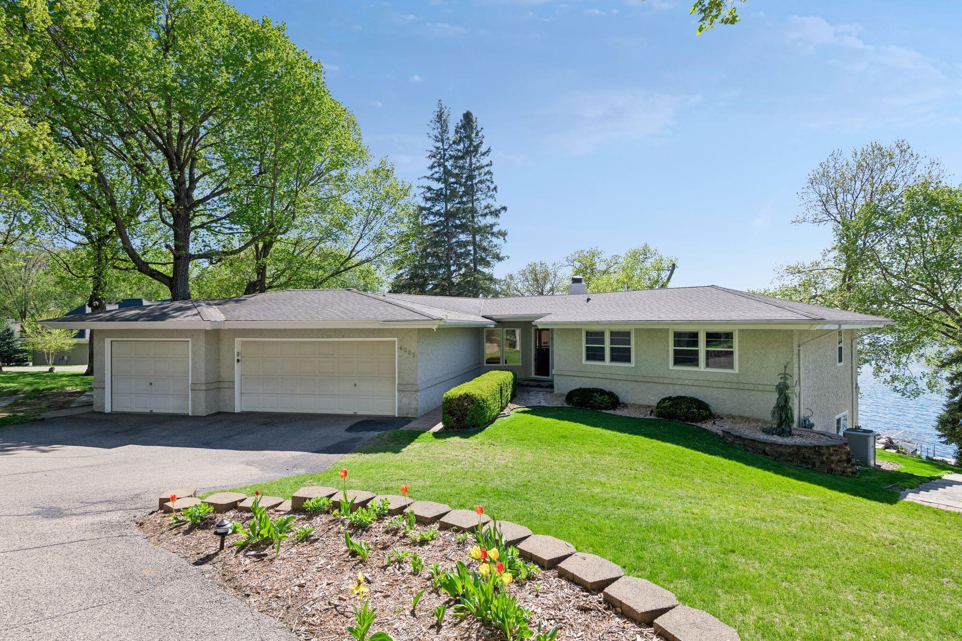 Welcome to this stunning 4 bed 4 bath rambler on over 100 ft of west facing lakeshore on Halstead Bay. Twilight view of the front exterior with spacious driveway and attached 3 car garage.