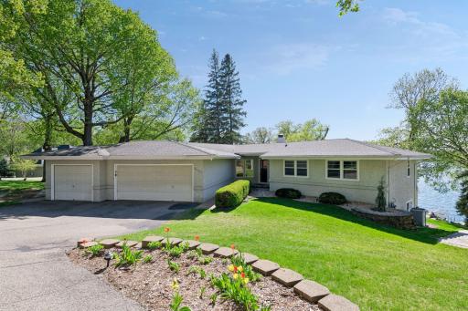 Front of home with 3 car garage and sprawling green space