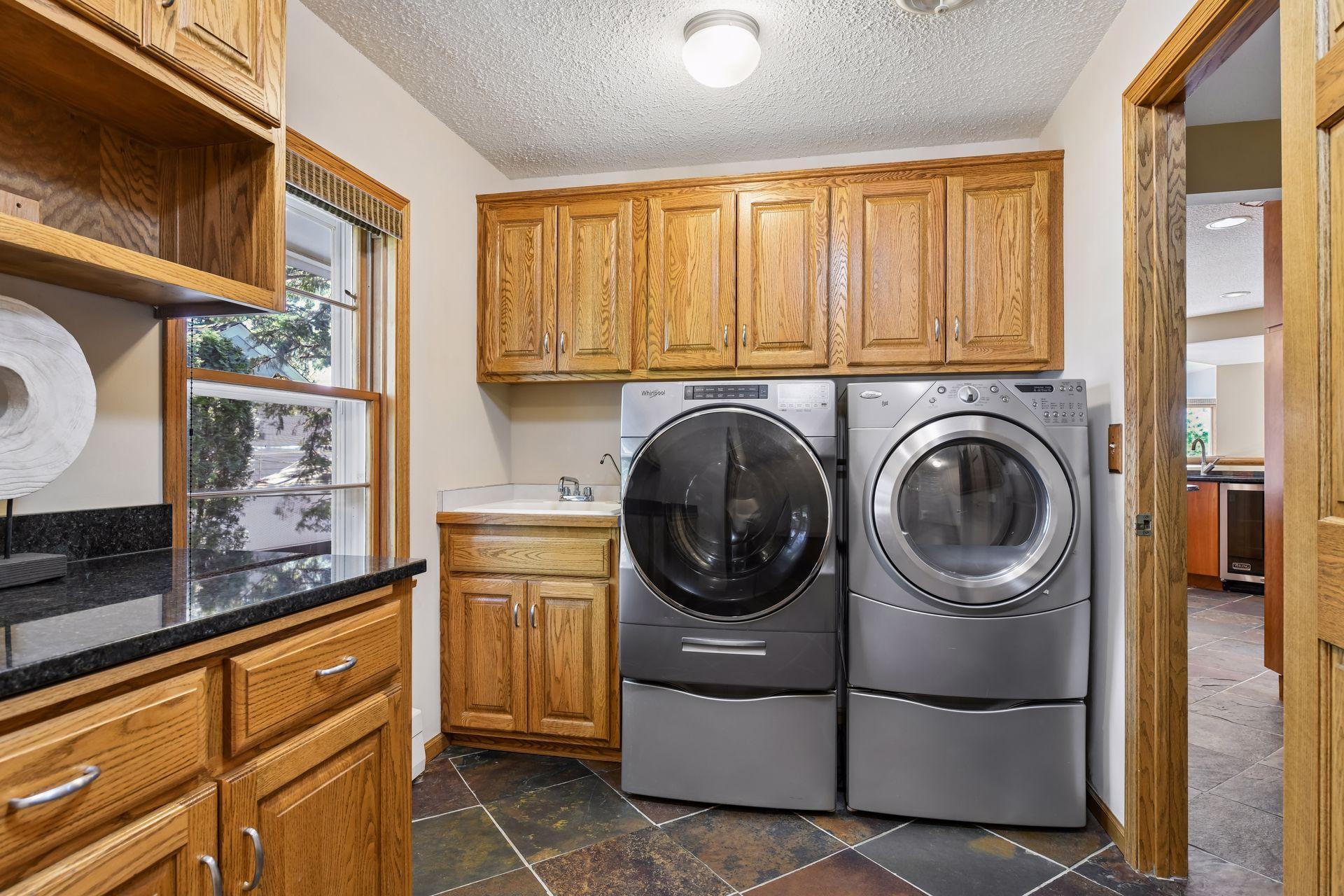Main level laundry room with ample cabinetry and counter space.