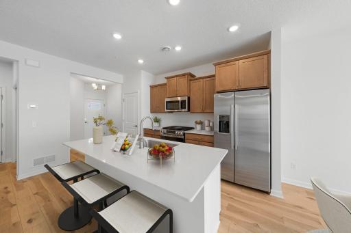 Kitchen features stained cabinets with gold hardware, white backsplash and all appliances included - for illustrative purposes only