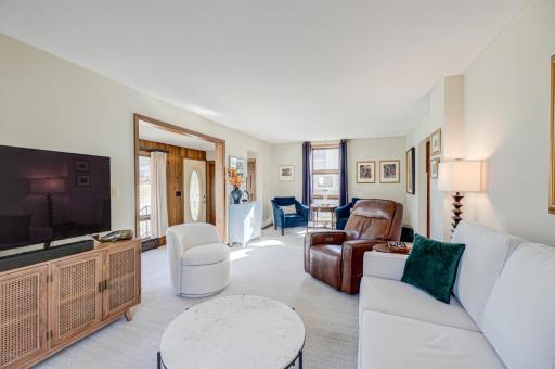 The light filled living room features large windows that bring in abundant natural light, while fresh paint, updated flooring throughout, and new light fixtures elevate every room.