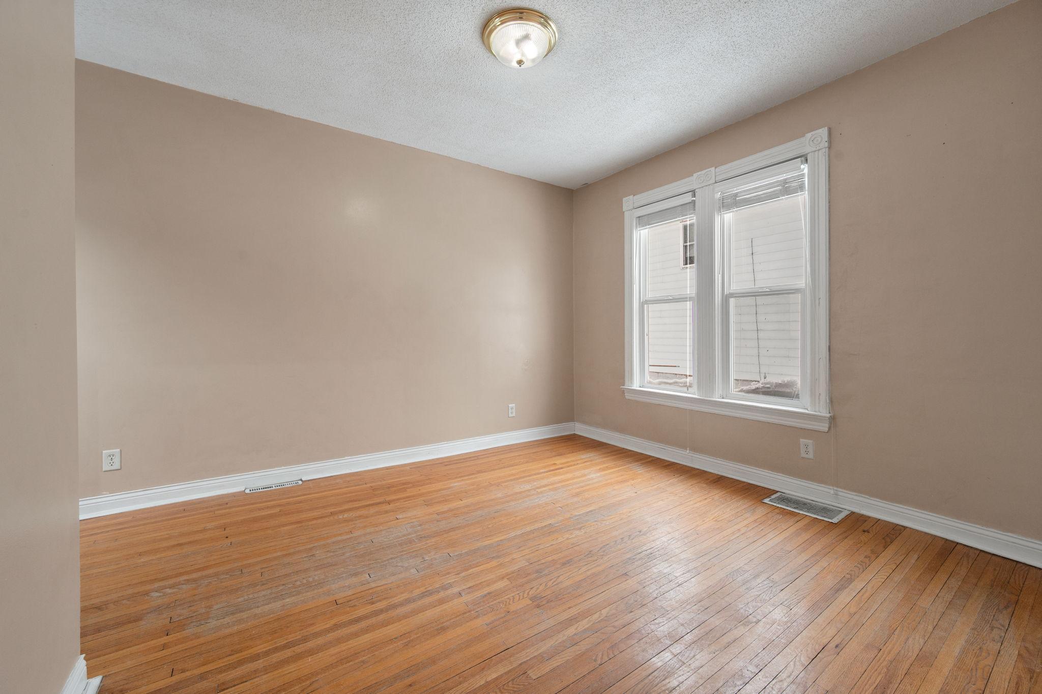 Back unit living room features original hardwood floors and new wood shutter blinds
