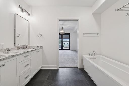Private primary bath with heated tiled floors, double vanity areas, and great cabinet space for storage.