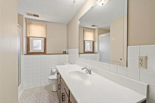 Three-quarter bath on lower level with tile floors.