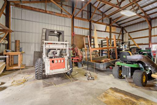Outbuilding has oversized sliding door in rear of shed.