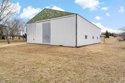 Back side of outbuilding has a sliding access door.
