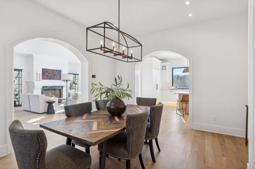 From the dining room the kitchen and living room are revealed through curved archways and create a unified and inviting atmosphere.