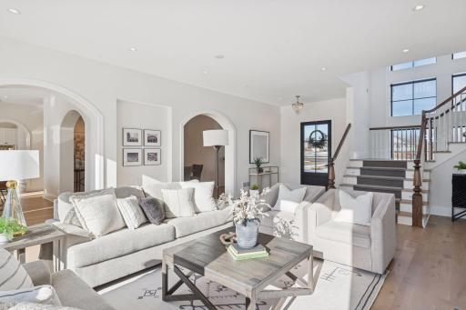 Beautifully designed living area with soaring ceilings, graceful archways, and an elegant staircase that creates a striking first impression.