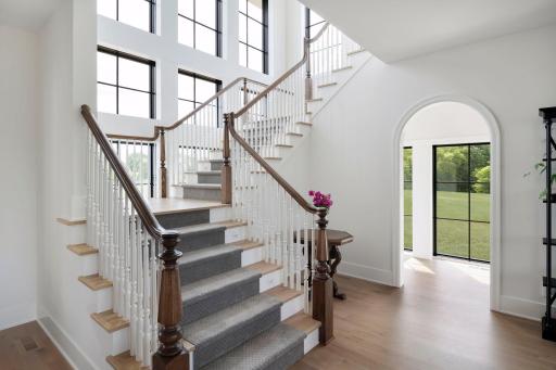 This stunning staircase sweeps upward and is complemented by a cascading wall of windows letting in natural light.