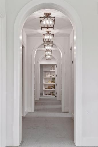 Beyond this stately hallway, a secret passage is camouflaged behind the shelves of this bookcase, disappearing completely when closed.