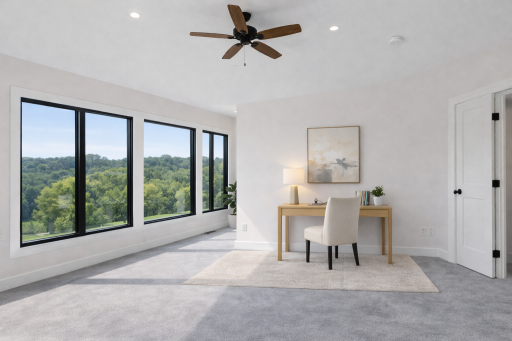 Versatile primary suite with dedicated home office or flex space, showcasing oversized windows and peaceful green views. (virtual staged)