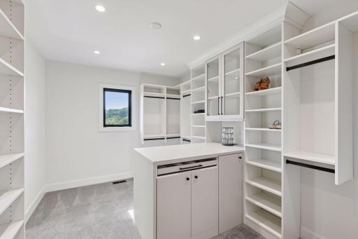 Private dressing suite with extensive custom built-ins, display shelving, and exceptional storage throughout.