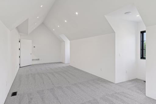 Private bonus room with vaulted ceilings and recessed lighting, offering flexible space for a media room, playroom, or studio.