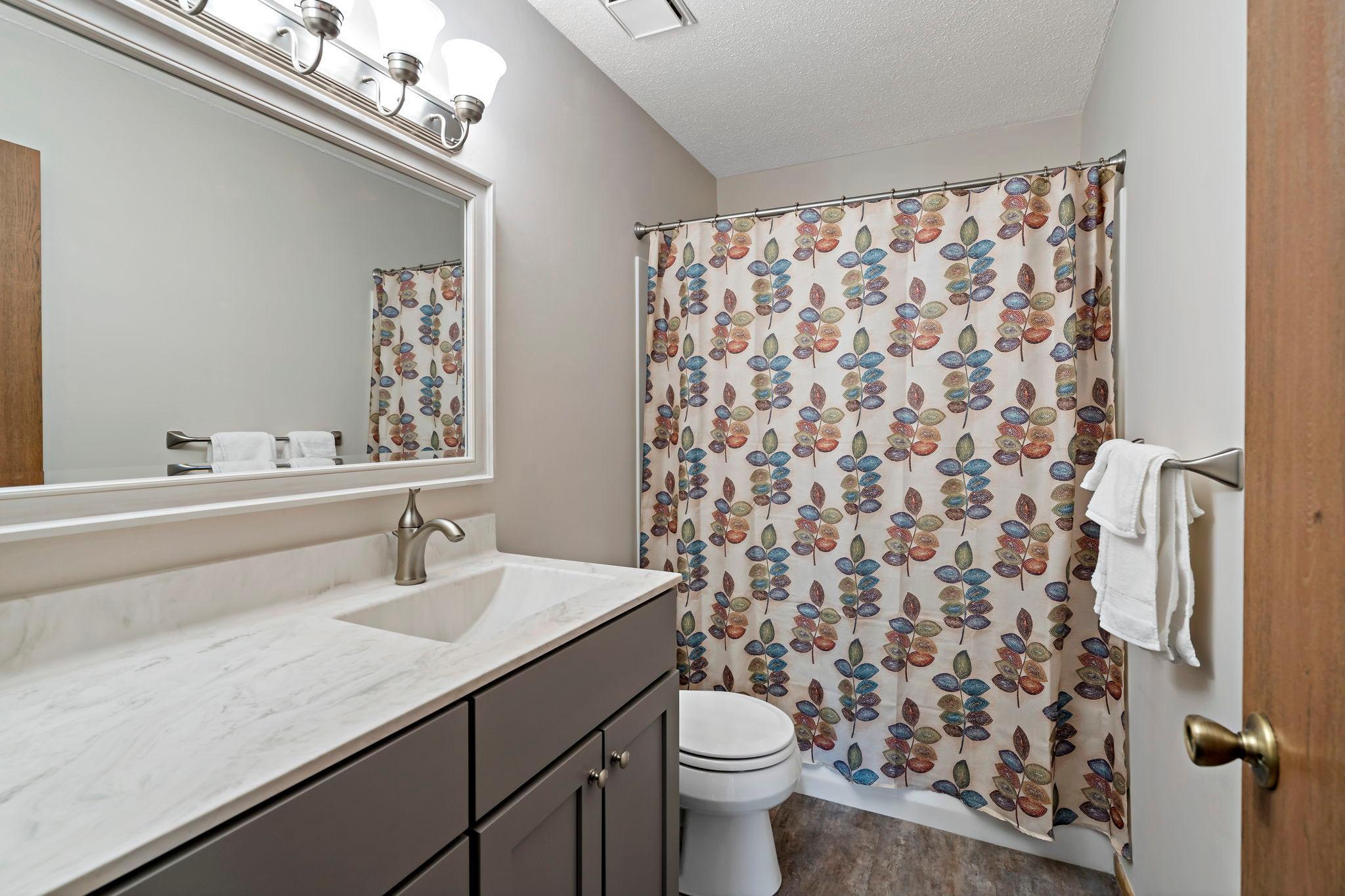 Updated upper level bath with newer flooring, vanity and lighing