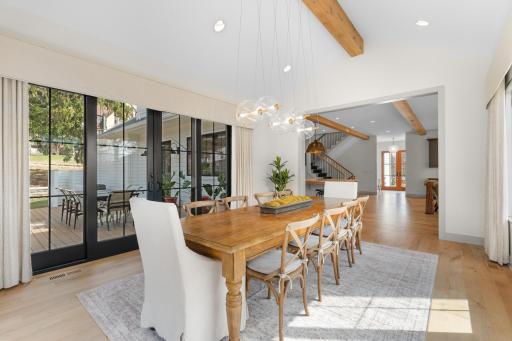 Expanded dining room with vaulted ceiling, commanding beam accents and patio access