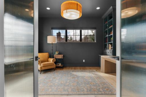 Main level office with built in desk and shelving